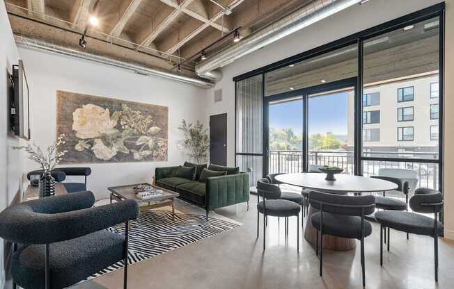 A living room with a large painting on the wall and a view of a balcony.