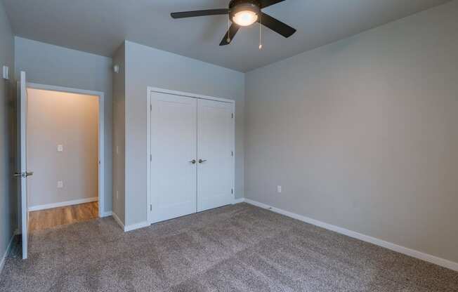 a bedroom with a ceiling fan and a closet. Fargo, ND Prairiewood Meadows