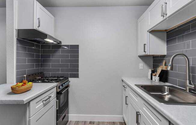 A kitchen with a stove, oven, and sink.