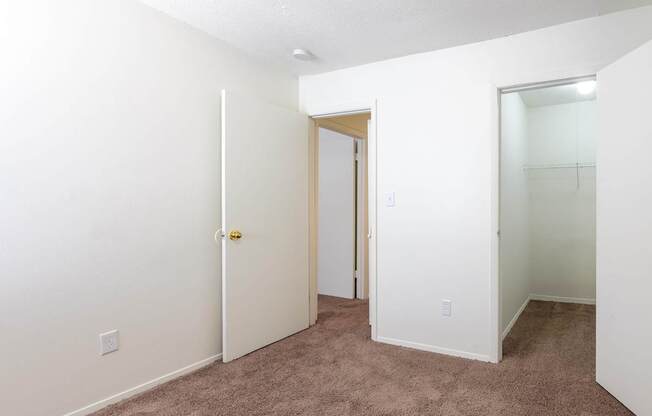 A white door with a gold handle is in a room with carpeted flooring at Spring Creek Townhomes Apartments, Illinois 62702