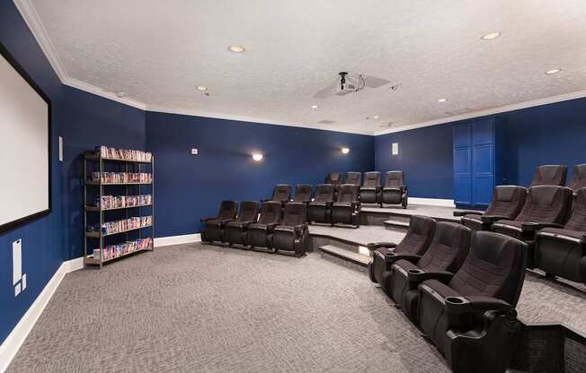 A room with a carpeted floor and a row of black chairs.