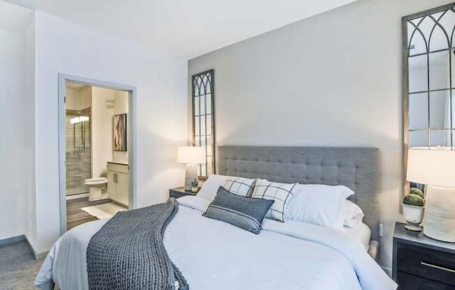 A bedroom with a large bed and a window with bars.