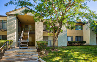 a building with stairs and a tree in front of it at Mountain Vista, Victorville, 92395