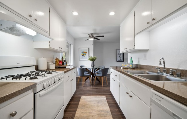 a kitchen with white cabinetry and a white stove top oven