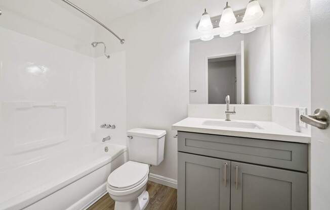 A white toilet sits next to a white sink in a bathroom.