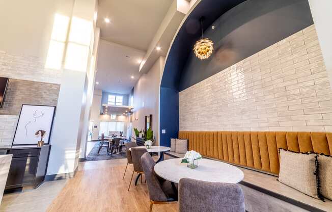 a lobby with tables and chairs and a brick wall