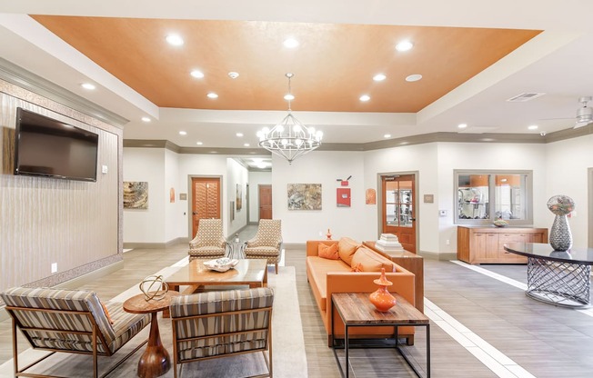 a living room with couches and chairs and a television at Cumberland Place Apartment Homes, Tyler, Texas