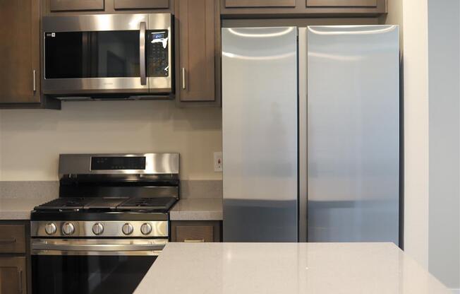 a kitchen with a stove microwave and refrigerator at Loma Villas Apartments, San Bernardino, 92408