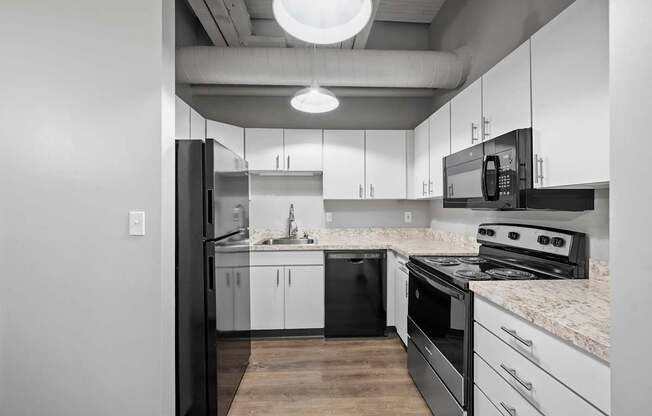 A modern kitchen with black and white appliances and cabinets.