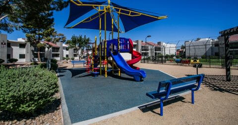 a playground with slides and benches in a park