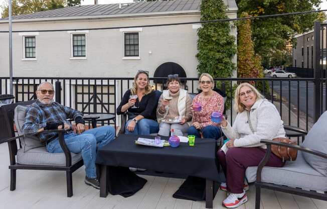 a group of people sitting around a table on a patio