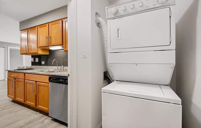 A white dryer is sitting next to a white washer in a small laundry room.
