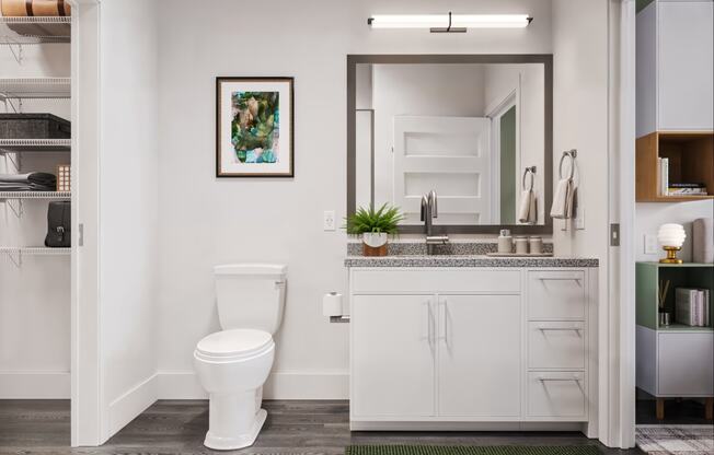 a bathroom with a toilet and a sink and a mirror at Link Apartments® CYKEL Apartments, Charlotte , NC 28208