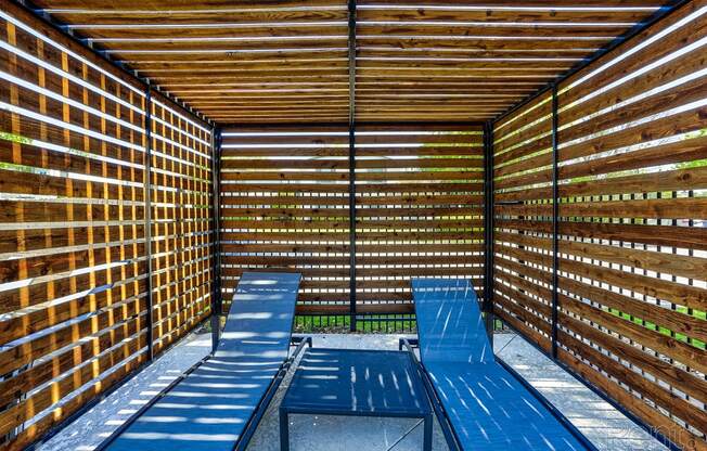 a covered patio with blue benches and tables