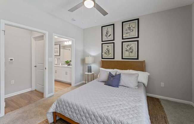 A bedroom with a large bed and a ceiling fan.
