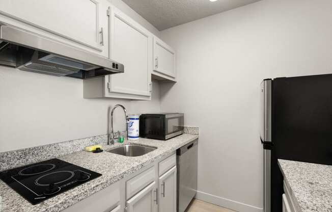 the kitchen of our studio apartment atrium with granite counter tops and white cabinets