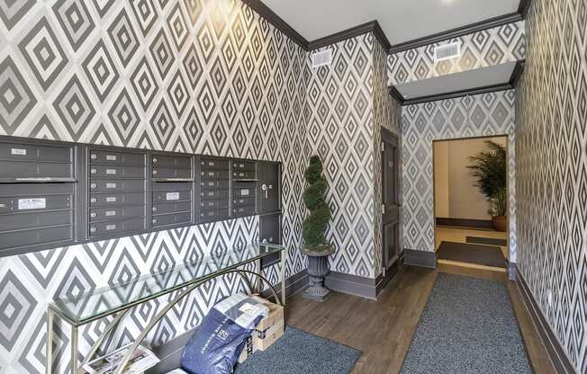 the lobby of a building with mailboxes and a tree in the corner at The Knights @ 506 Delaware Apartments, Buffalo