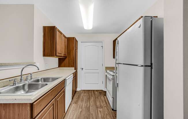 an empty kitchen with a refrigerator and a sink