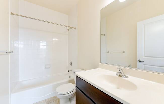 bathroom with tub, sink, toilet, and large mirror at sheridan station south townhomes in washington dc