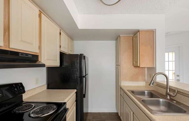 A kitchen with black appliances and wooden cabinets.