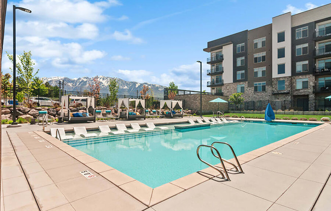Community Swimming Pool with Pool Furniture  at Seven Skies Apartments located in Sandy, UT.
