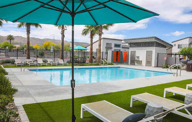 our apartments have a pool and lounge chairs with an umbrella