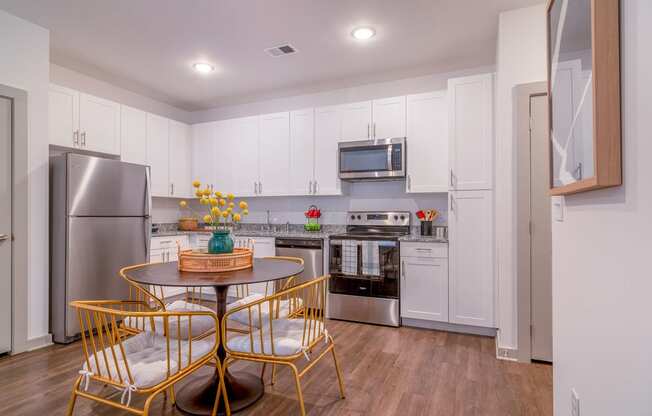 a kitchen with white cabinets and a table and chairs at Carmel Vista, McDonough, Georgia