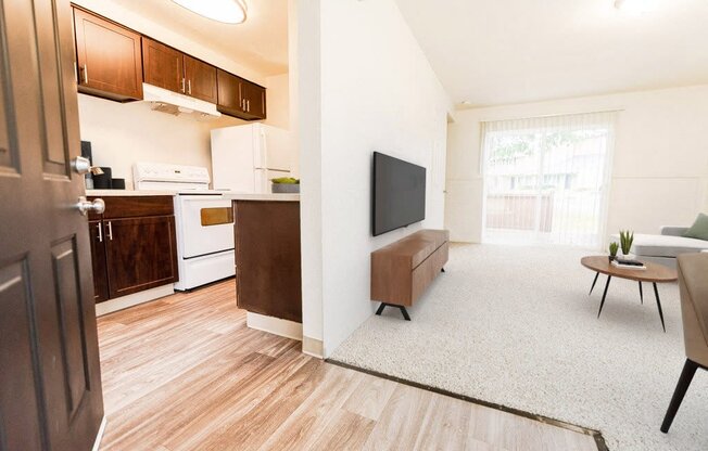 a living room and kitchen with a tv