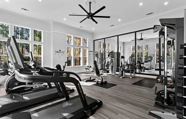 A gym with treadmills, weights, and exercise equipment.