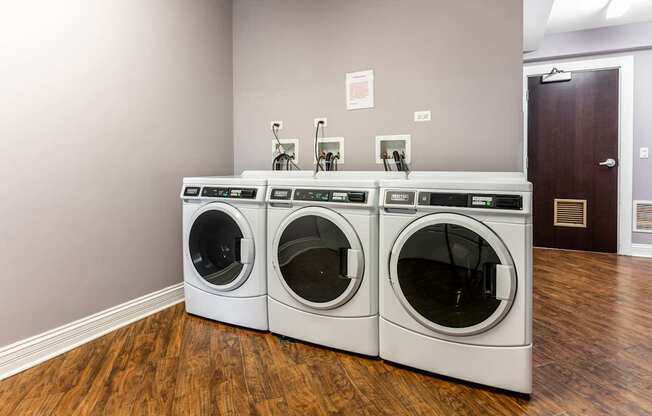 a washer and dryer in a laundry room with two washing machines