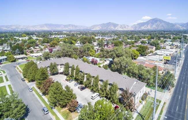 an aerial view of a neighborhood with trees and mountains in the background