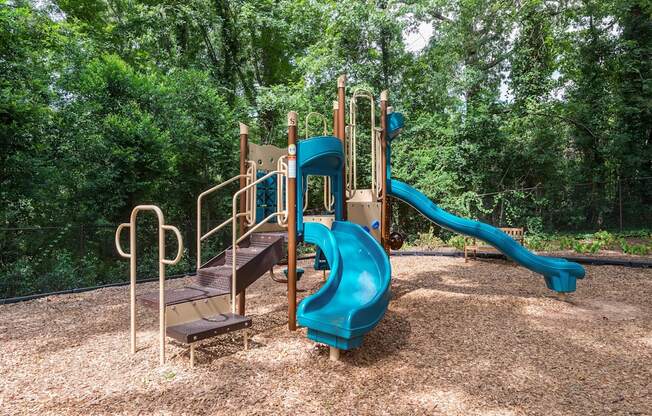 A playground with a blue slide and a brown wooden platform.