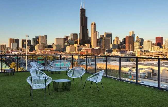 a view of the city skyline from a balcony with chairs and tables