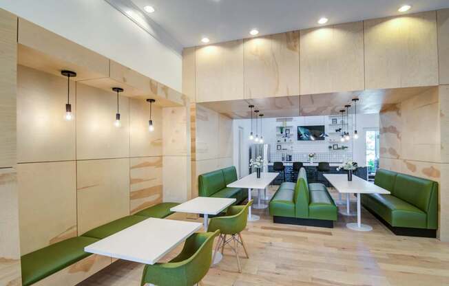A modern dining area with green chairs and tables.