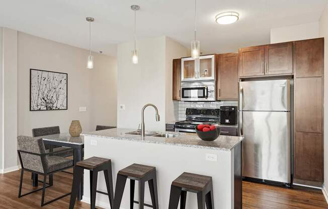A kitchen with a white countertop and a stainless steel refrigerator.