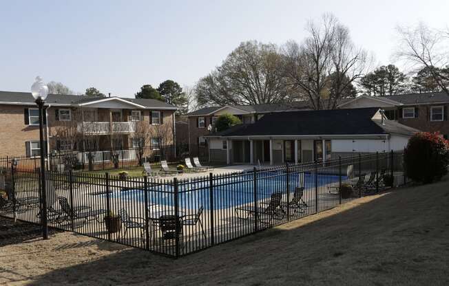 a pool in front of a house with a fence