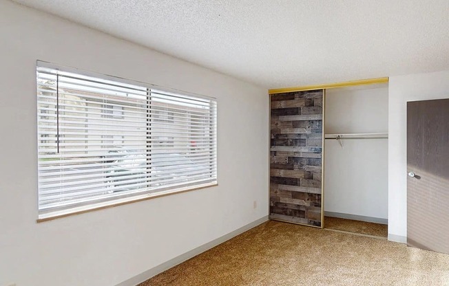 a living room with a large window and a door to a closet