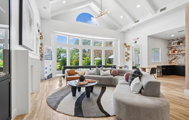 A living room with a large grey couch and a coffee table in the center.