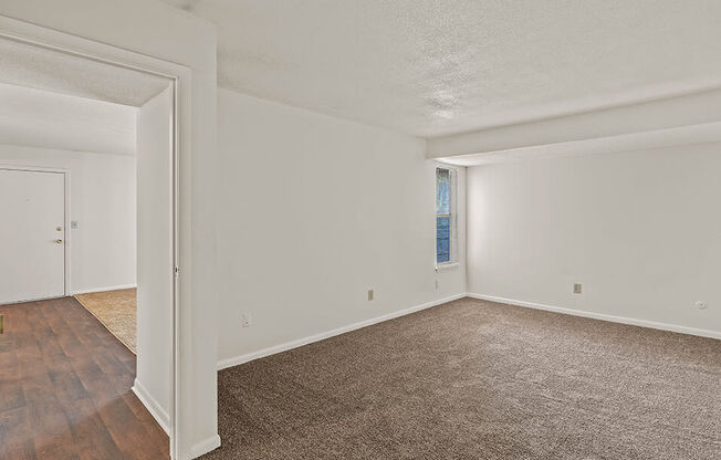 an empty living room with wood flooring and white walls