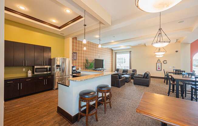 a kitchen with a bar and a living room with a table and chairs