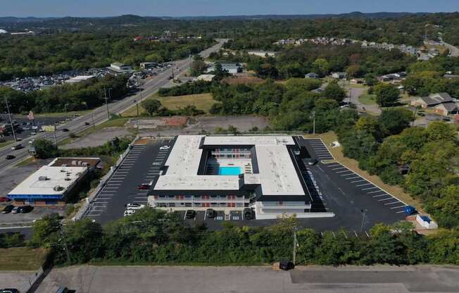An aerial view of a large building with a parking lot in front.