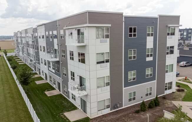 an aerial view of an apartment building with green grass and a parking lot