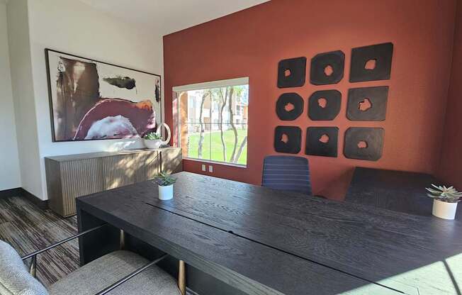 A room with a brown wall and a black table.