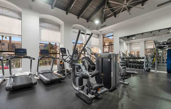 A gym with treadmills, elliptical machines, and other exercise equipment.