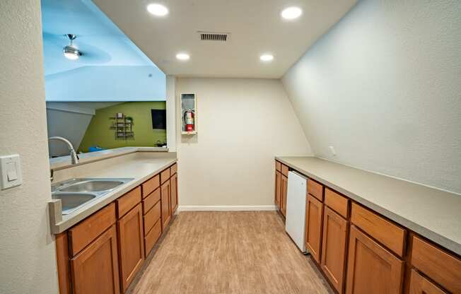 a kitchen with wooden cabinets and a sink and a mirror