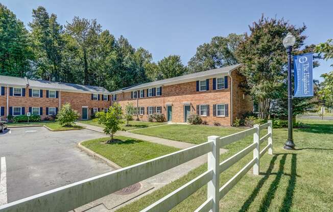 the front of a brick building with a white fence