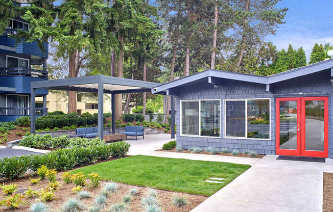 Exterior view of leasing office. Manicured garden and lawn in front of office. Office is blue with a red door and path to the front door. at 3030 Lake City, Seattle, Washington