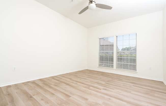 a bedroom with hardwood floors and white walls