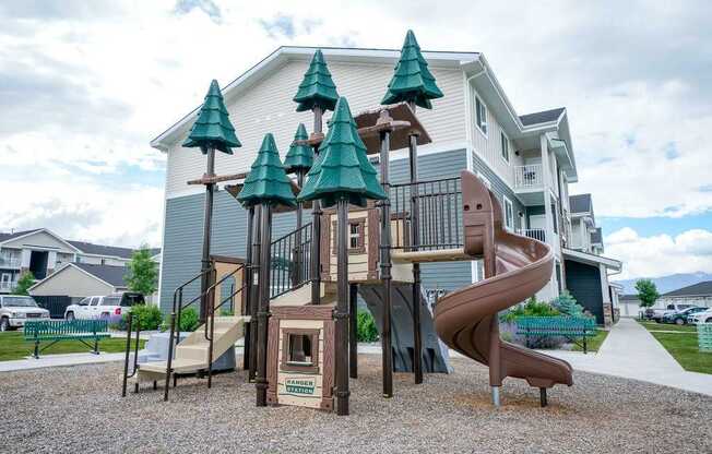 A playground with a slide and a tree-shaped structure.