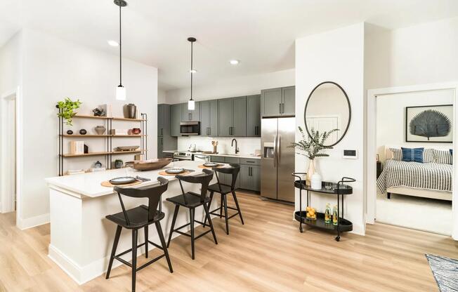 The gourmet kitchens at Modera Liberty Row offer two finish packages, including an option for modern gray cabinetry with black hardware, stainless steel appliances, white quartz countertops, and polished white horizontal tile.